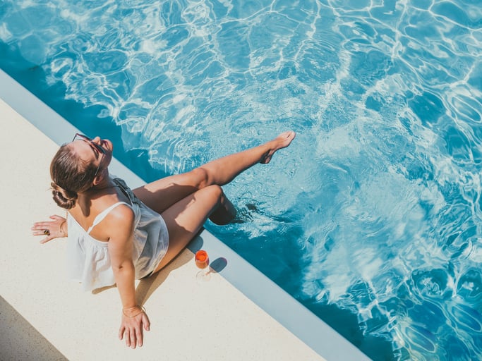 pool liner replacement - woman sitting poolside with her feet in the water